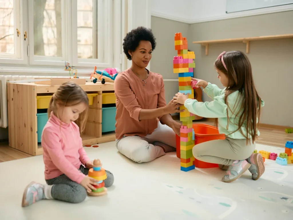 happy black teacher and preschool kids playroom