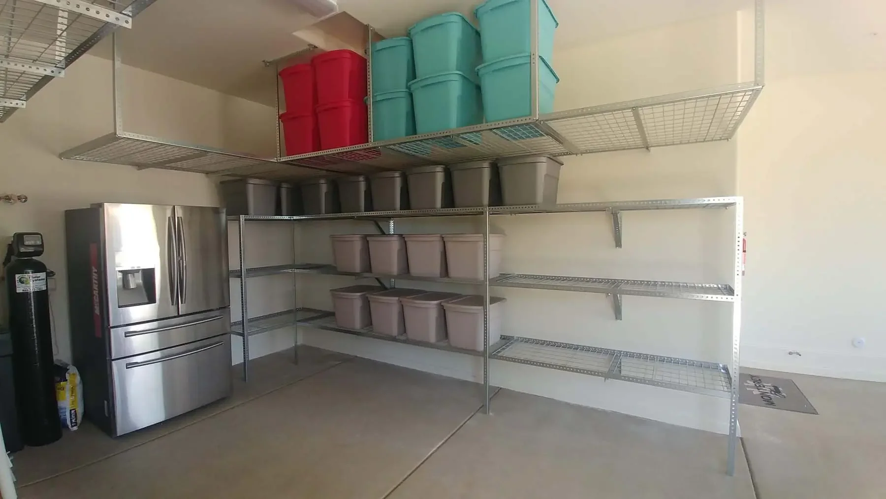 Organized garage with labeled bins on metal shelving along the wall